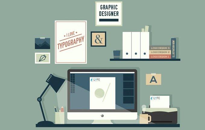 Computer at a desk with posters of design posted on wall