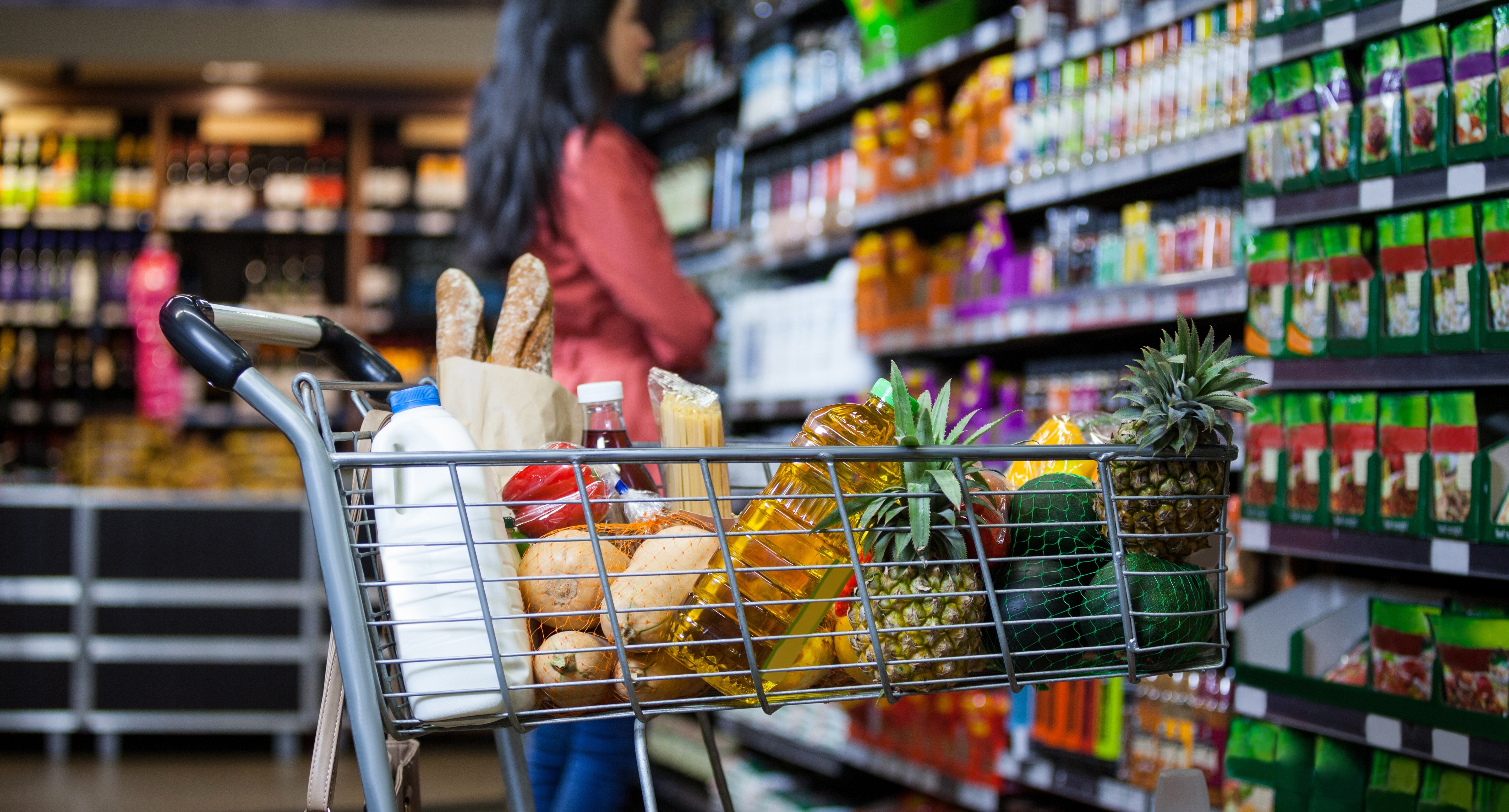 A shopping cart full of groceries in a store.
